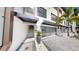 Modern townhome exterior with a grey garage and stone accents and manicured landscaping at 774 Gran Kaymen Way, Apollo Beach, FL 33572