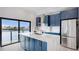 Modern kitchen featuring blue cabinets, stainless appliances, marble countertops and a water view at 774 Gran Kaymen Way, Apollo Beach, FL 33572