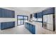 Modern kitchen with blue cabinets, marble countertops, and stainless steel appliances overlooking the water at 774 Gran Kaymen Way, Apollo Beach, FL 33572