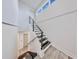 Modern staircase with black steps and bright white walls with wood-look floors at 774 Gran Kaymen Way, Apollo Beach, FL 33572