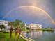 Exterior view of condo buildings in a waterfront community under a full rainbow in the sky at 7892 Sailboat Key S Blvd # 307, South Pasadena, FL 33707