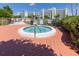 Inviting hot tub area featuring a circular tub, greenery, and views of nearby buildings at 7892 Sailboat Key S Blvd # 307, South Pasadena, FL 33707