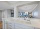 Bright kitchen features white cabinetry and sink and a peek into the living area with beautiful water views at 7892 Sailboat Key S Blvd # 307, South Pasadena, FL 33707