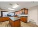 Well-lit kitchen featuring wooden cabinetry, an island, stainless steel appliances, and stylish flooring at 7892 Sailboat Key S Blvd # 307, South Pasadena, FL 33707