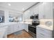 Modern white kitchen with stainless steel appliances and a view to the living room and balcony at 7892 Sailboat Key S Blvd # 307, South Pasadena, FL 33707