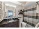 Modern bathroom featuring a granite vanity, framed mirror, and a stylish shower curtain with coordinated shelving at 800 S Dakota Ave # 323, Tampa, FL 33606