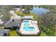 Aerial view of a community pool with a lake, ample parking, and a well-maintained surrounding landscape at 8004 Downpatrick Ct, Tampa, FL 33610