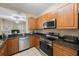 Kitchen features stainless steel appliances, wood cabinets, and granite countertops at 8004 Downpatrick Ct, Tampa, FL 33610