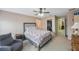 Bright main bedroom features a ceiling fan, comfortable chair, and access to a walk-in closet at 8004 Downpatrick Ct, Tampa, FL 33610