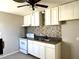 Functional kitchen featuring white cabinets, mosaic backsplash, and modern appliances at 808 20Th W Ave, Bradenton, FL 34205