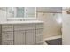 Bathroom vanity with taupe cabinets, white sink, tile floors, and neutral tiled walls at 9040 Lunar Ln, Port Richey, FL 34668