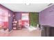 A bedroom with pink decor, pink window treatments, and a unique artificial grass wall hanging for visual interest at 9040 Lunar Ln, Port Richey, FL 34668
