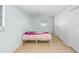 Bedroom with neutral tile floors, closet, one small window, and simple bed frame at 9040 Lunar Ln, Port Richey, FL 34668