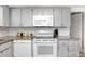 Bright kitchen features granite countertops, white subway tile backsplash, and white appliances at 9040 Lunar Ln, Port Richey, FL 34668