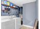Laundry room with washer, dryer, open shelving, and blue painted walls at 9040 Lunar Ln, Port Richey, FL 34668