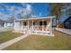 Lovely bungalow featuring a welcoming front porch, decorative trim, and verdant lawn at 1053 56Th N Ave, St Petersburg, FL 33703