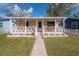 Cozy front porch with white railings, red flooring, and orange outdoor furniture at 1053 56Th N Ave, St Petersburg, FL 33703