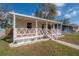 Quaint home with a covered front porch, decorative trim, and verdant lawn at 1053 56Th N Ave, St Petersburg, FL 33703