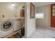 Functional laundry room with washer, dryer, and ample shelving for storage and organization at 1053 56Th N Ave, St Petersburg, FL 33703