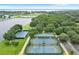 Aerial view showcasing community amenities: two tennis courts, a basketball court and a park area near a waterfront at 112 Brent Cir, Oldsmar, FL 34677