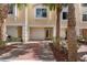 Exterior facade of a charming condo featuring a garage, front door, and brick paver driveway at 112 Brent Cir, Oldsmar, FL 34677