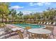 A relaxing community pool with lounge chairs and patio furniture surrounded by tropical landscaping on a sunny day at 112 Brent Cir, Oldsmar, FL 34677