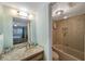 Bright bathroom boasting a granite vanity top and tiled tub and shower at 1125 Pinellas Bayway S # 305, St Petersburg, FL 33715