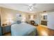 Cozy bedroom featuring a ceiling fan, hardwood floors, and adjacent bathroom entrance at 1125 Pinellas Bayway S # 305, St Petersburg, FL 33715