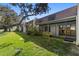 Low angle view of a home with a lawn and a line of windows looking out to the backyard at 11410 Carriage Hill Dr # 3, Port Richey, FL 34668