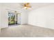 This carpeted bedroom has white walls and sliding doors opening to a screened porch at 11410 Carriage Hill Dr # 3, Port Richey, FL 34668