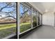 View of lush greenery from the screened porch with neutral ceiling and flooring at 11410 Carriage Hill Dr # 3, Port Richey, FL 34668