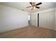 Cozy bedroom featuring wood-look floors, ceiling fan, closet, and an ensuite bathroom at 1152 Viking Dr, Holiday, FL 34691