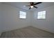 Bright bedroom featuring wood-look floors, two windows, and neutral walls at 1152 Viking Dr, Holiday, FL 34691