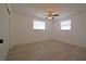 Well-lit bedroom with wood-look floors, a ceiling fan, and two windows for ample natural light at 1152 Viking Dr, Holiday, FL 34691