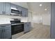 Modern kitchen featuring gray cabinets, stainless steel appliances, and a mosaic tile backsplash at 1152 Viking Dr, Holiday, FL 34691