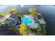 Aerial view of the community pool, deck with table, and lush landscaping alongside the lake at 11901 4Th N St # 10102, St Petersburg, FL 33716