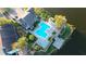 Aerial view of the community pool, deck with table, and lush landscaping alongside the lake at 11901 4Th N St # 10102, St Petersburg, FL 33716