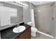 This bathroom has a tiled shower with a pebble floor and a dark granite countertop at 11901 4Th N St # 10102, St Petersburg, FL 33716