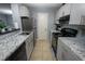 Well-lit kitchen features granite countertops, stainless steel appliances, and light gray cabinetry at 11901 4Th N St # 10102, St Petersburg, FL 33716