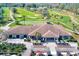 An aerial shot showcases the community clubhouse, nestled on the golf course, along with the parking lot for golf carts at 12607 San Blas Loop, Largo, FL 33774