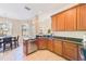 Kitchen with stainless steel dishwasher, granite counters, wood cabinets and tile flooring at 12607 San Blas Loop, Largo, FL 33774