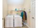 Practical laundry room includes a washer, dryer, and shelving for efficient organization at 12607 San Blas Loop, Largo, FL 33774