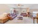 Cozy living room featuring comfortable leather sofas, ceiling fan, and abundant natural light at 12607 San Blas Loop, Largo, FL 33774