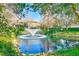 Scenic community pond featuring a fountain and beautiful landscaping on a sunny day at 12607 San Blas Loop, Largo, FL 33774