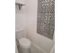 Cozy half bathroom with tiled accent wall, modern toilet, and a floating shelf at 1321 W North B St, Tampa, FL 33606