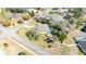 Aerial view of a home with mature trees, a screened-in pool, and surrounding neighborhood landscape at 13855 Rudi Loop, Spring Hill, FL 34609