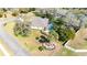 Aerial view of a home with a screened-in pool, palm trees, and a neighborhood entrance sign at 13855 Rudi Loop, Spring Hill, FL 34609