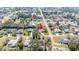 Aerial view of a home nestled in a quiet neighborhood with mature trees, featuring a red arrow for focus at 13855 Rudi Loop, Spring Hill, FL 34609