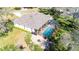 Aerial view shows a home with a screened-in pool, an outdoor kitchen, and a brick-paved patio at 13855 Rudi Loop, Spring Hill, FL 34609