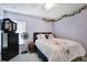 Comfortable bedroom featuring ceiling fan, black dresser, floral comforter, and a window at 13855 Rudi Loop, Spring Hill, FL 34609